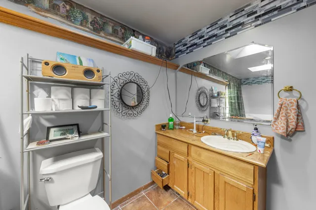 a bathroom with a granite countertop sink mirror vanity and toilet