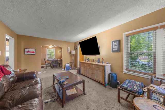 a living room with furniture a flat screen tv and a window