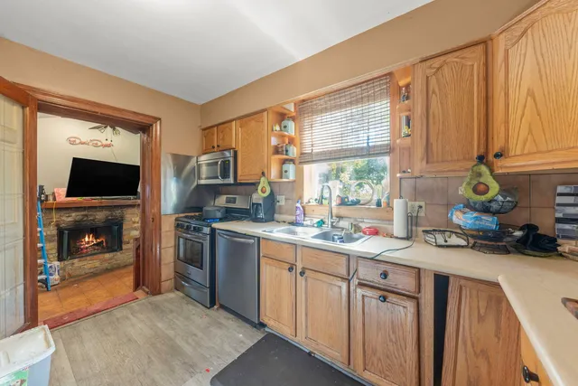 a kitchen with stainless steel appliances granite countertop a stove a sink and a microwave