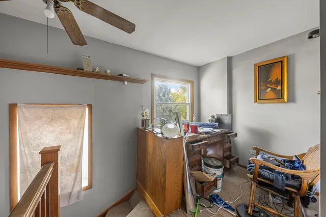 a view of a workspace with furniture and a window