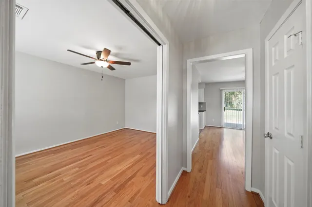 a view of a hallway with wooden floor