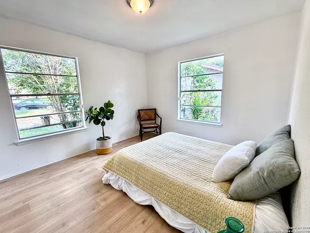 a bedroom with a bed and a large window
