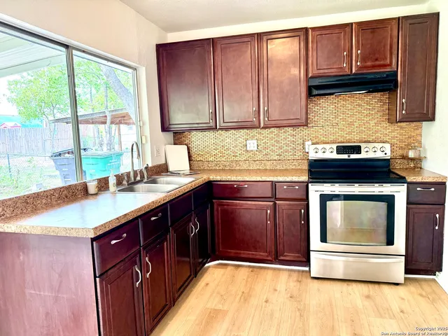 a kitchen with stainless steel appliances granite countertop a sink stove and cabinets