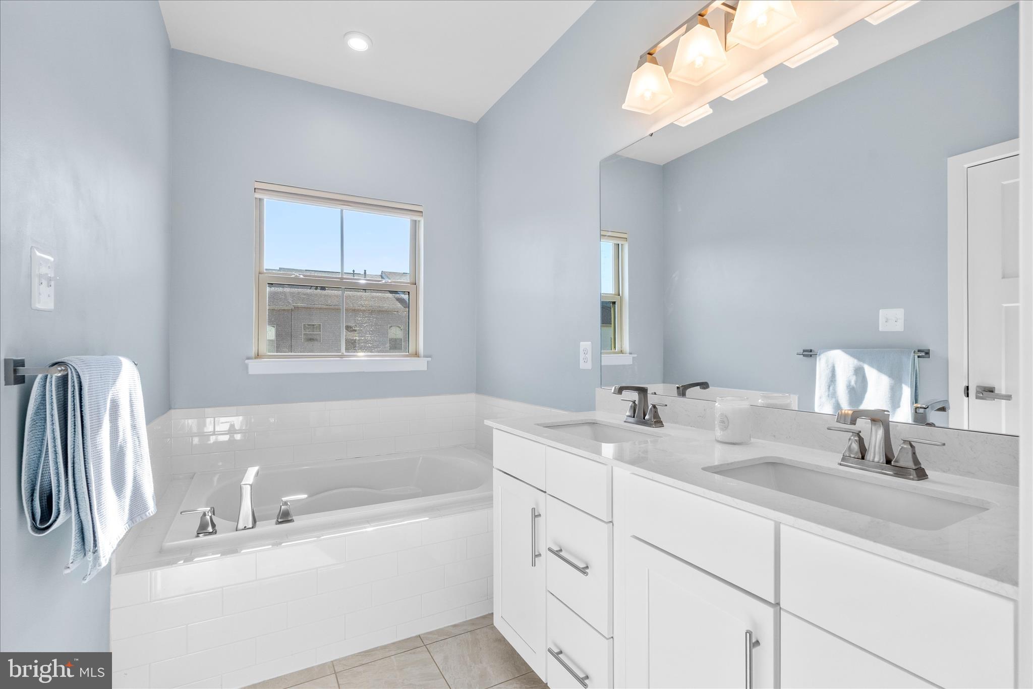 10327 Quillback Street New Market, MD 21774 - Photo 24 of 50 a bathroom with a double vanity sink window and a bathtub