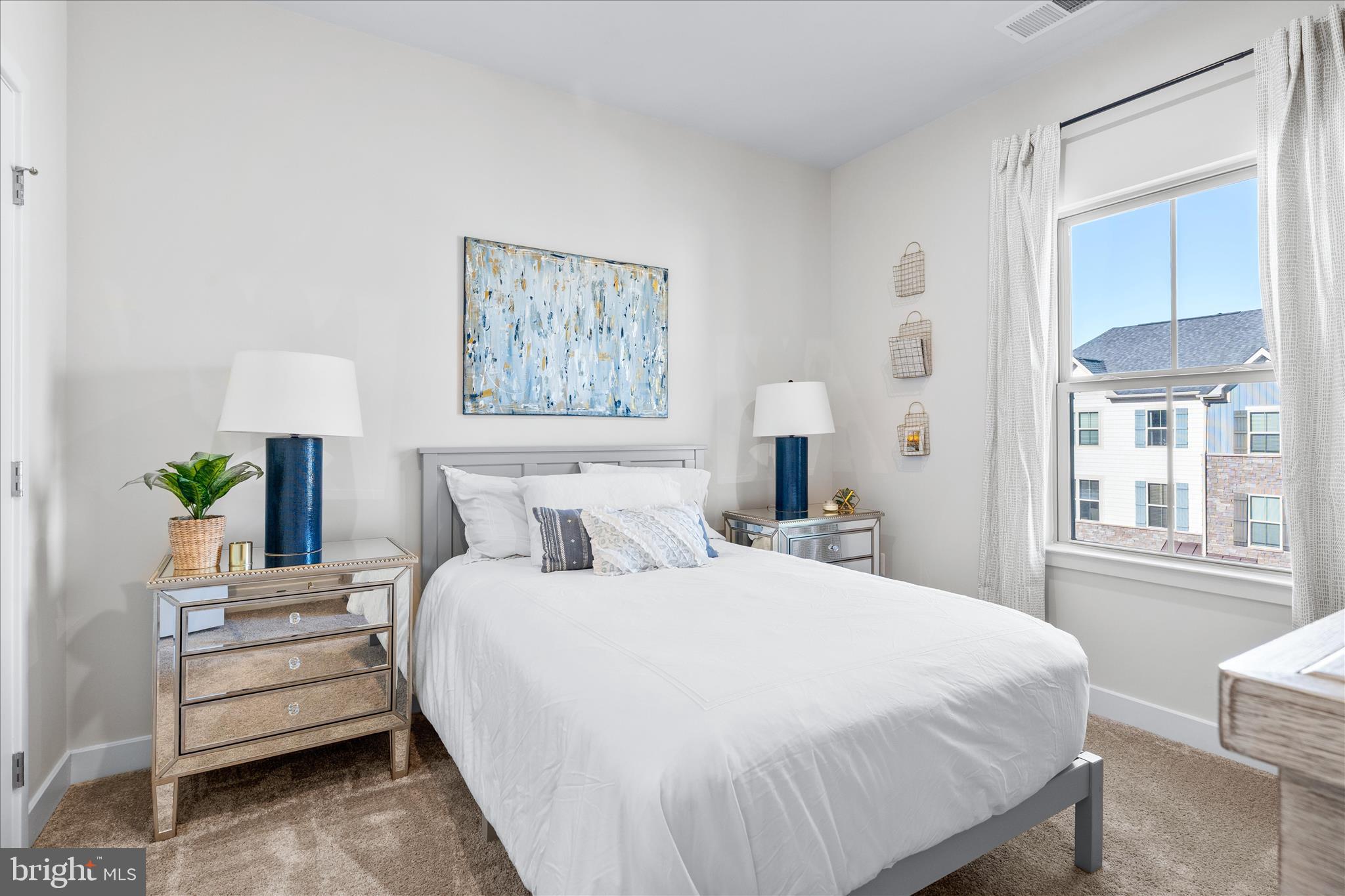 10327 Quillback Street New Market, MD 21774 - Photo 26 of 50 a bedroom with a bed a lamp and a large mirror