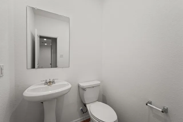 a bathroom with a sink a toilet and mirror