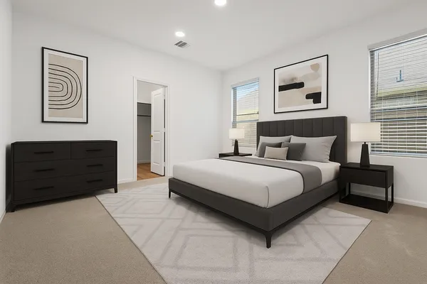 a bedroom with a bed lamp and paintings on the wall