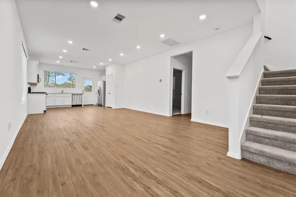 a view of a kitchen with wooden floor and electronic appliances