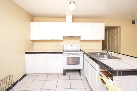 a kitchen with a sink stove and cabinets