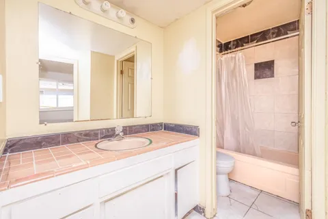a bathroom with a granite countertop sink a mirror and a bathtub
