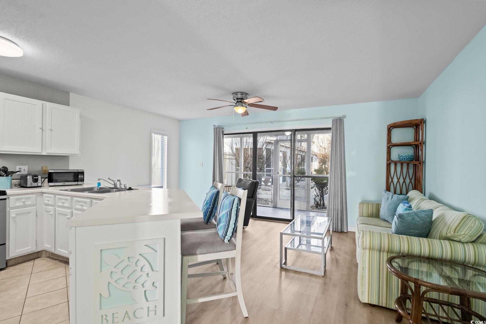 1890 Colony Drive, Unit 16I Myrtle Beach, SC 29575 - Photo 13 of 35 Kitchen featuring light countertops, a kitchen bar, a peninsula, white cabinets, and a ceiling fan