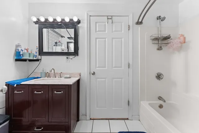 a bathroom with a tub sink and mirror
