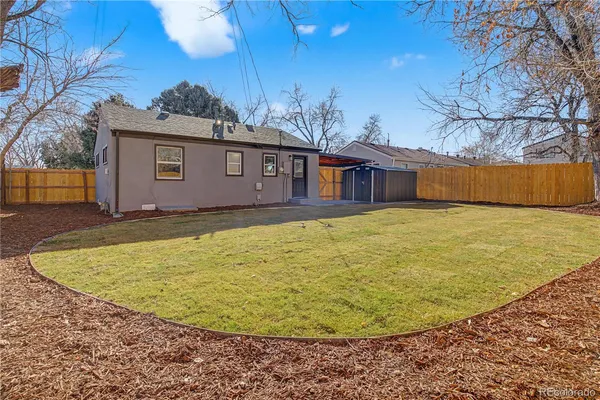 a view of a house with backyard and trees