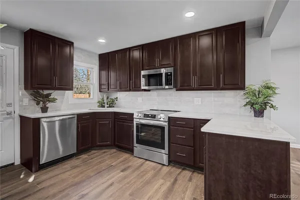 a kitchen with granite countertop wooden cabinets and stainless steel appliances