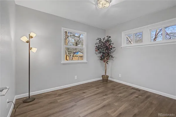 a view of a room with wooden floor and a potted plant
