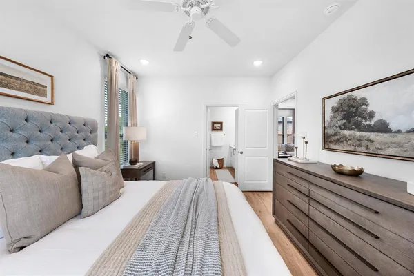 a spacious bedroom with a bed and a flat screen tv