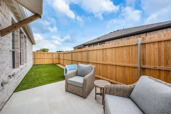 a backyard of a house with wooden floor and outdoor seating