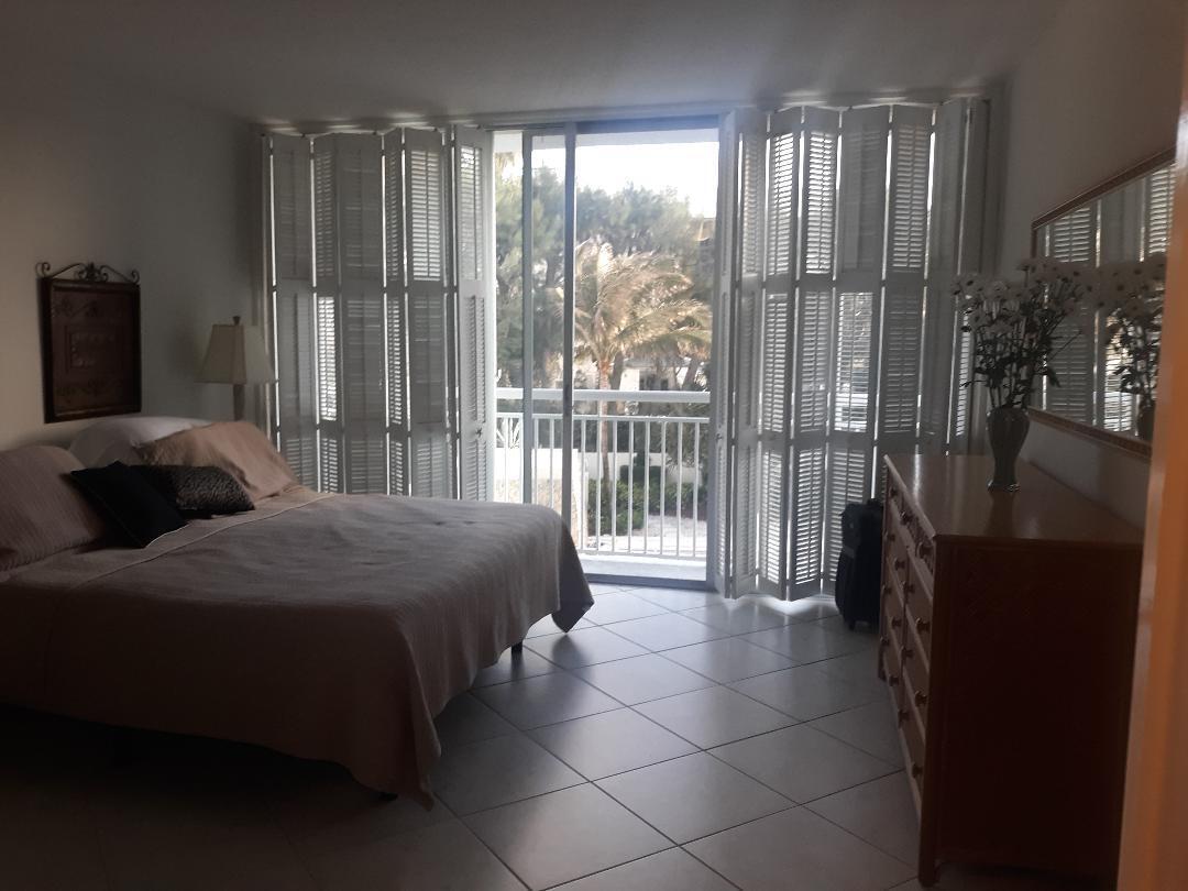 2780 South Ocean Boulevard, Unit 207 Palm Beach, FL 33480 - Photo 7 of 8 a bedroom with a bed and a large window