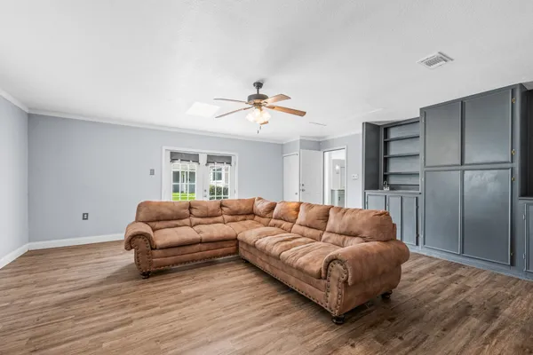 a view of empty room with wooden floor and ceiling fan