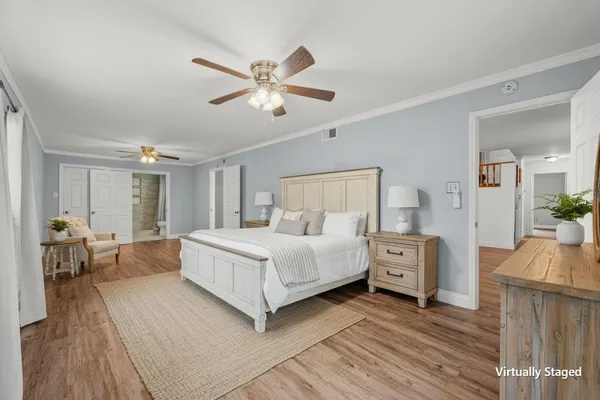 a view of empty room with wooden floor and fan