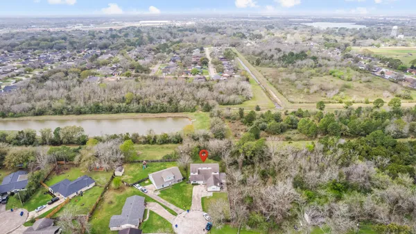 an aerial view of residential houses with outdoor space and trees