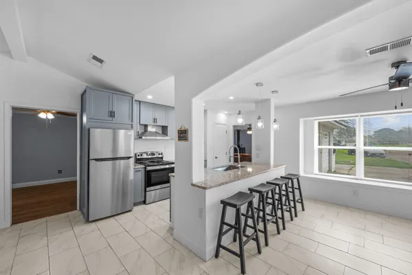 a kitchen with stainless steel appliances a refrigerator and a stove top oven