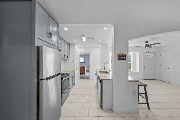 a kitchen with stainless steel appliances granite countertop a refrigerator sink and stove