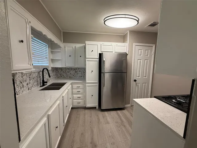 a kitchen with a refrigerator and a sink