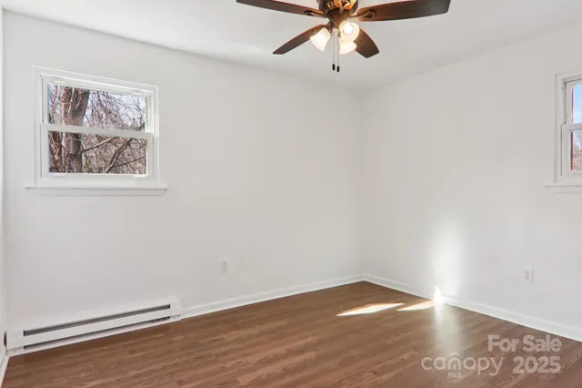 an empty room with a window and wooden floor