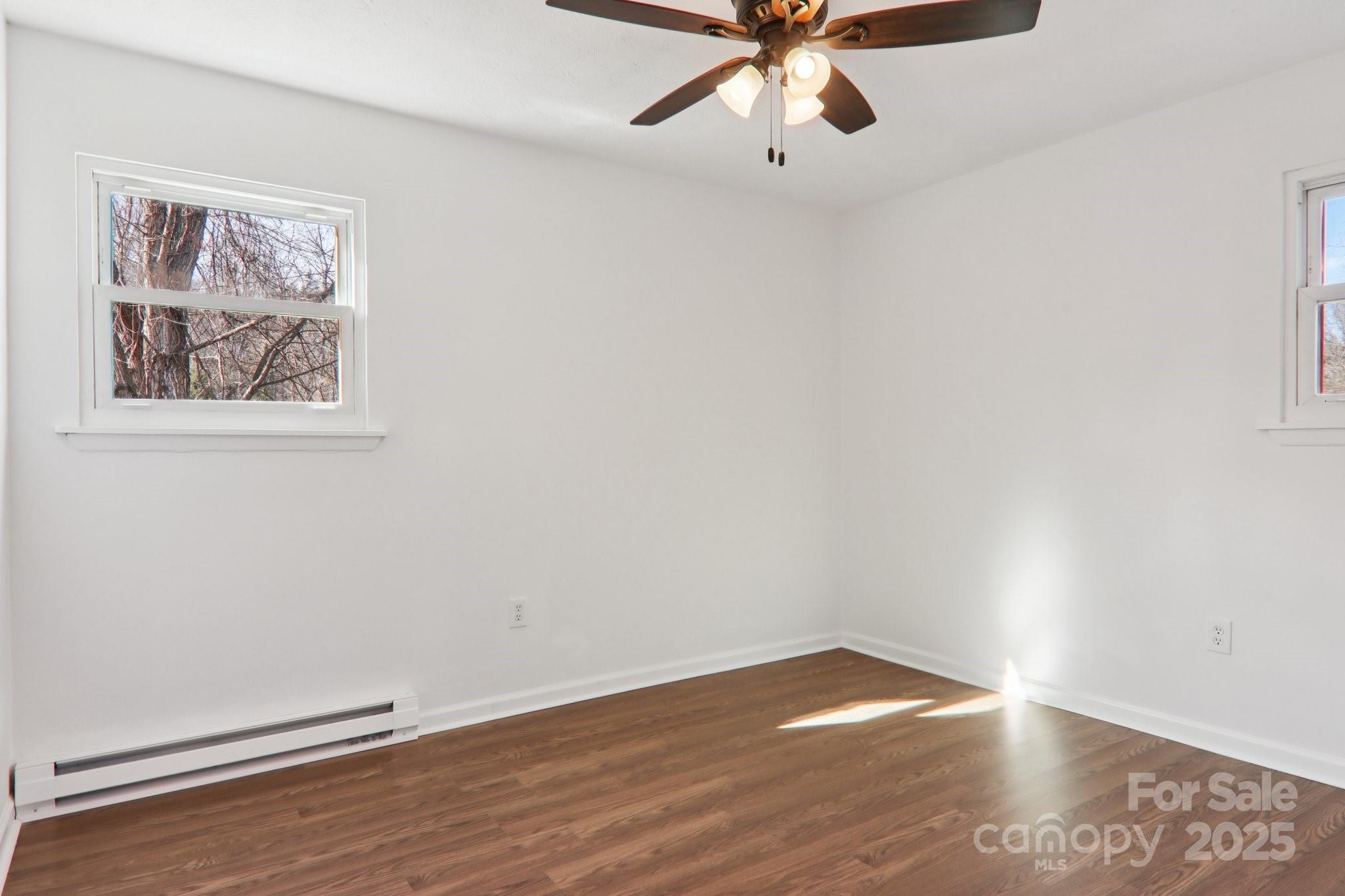 591 Blue Ridge Road Black Mountain, NC 28711 - Photo 15 of 32 an empty room with a window and wooden floor