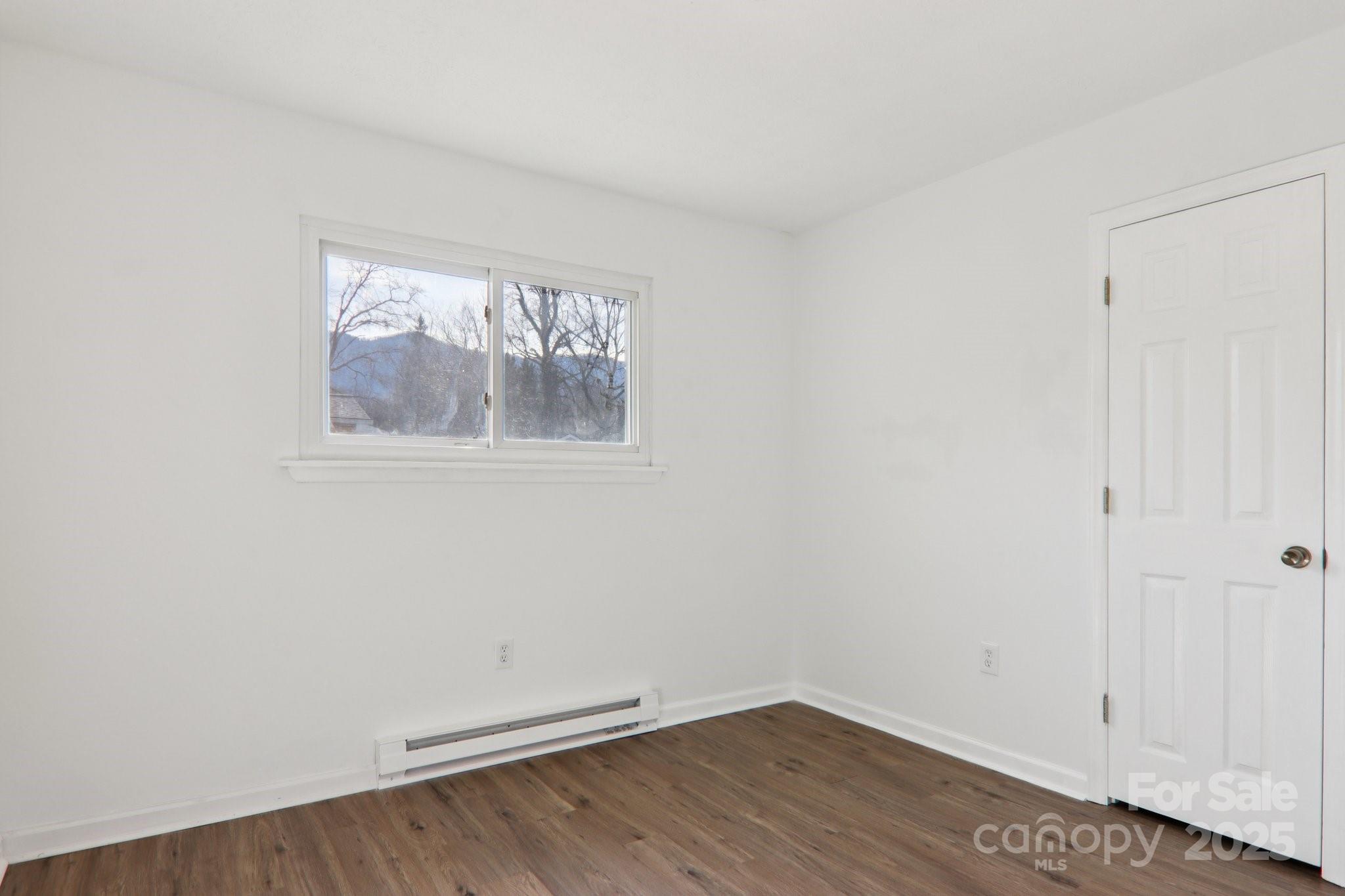 591 Blue Ridge Road Black Mountain, NC 28711 - Photo 20 of 32 an empty room with wooden floor and windows