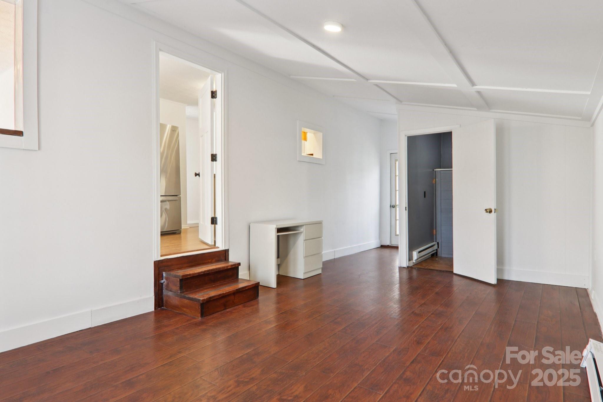 591 Blue Ridge Road Black Mountain, NC 28711 - Photo 22 of 32 an empty room with wooden floor and windows