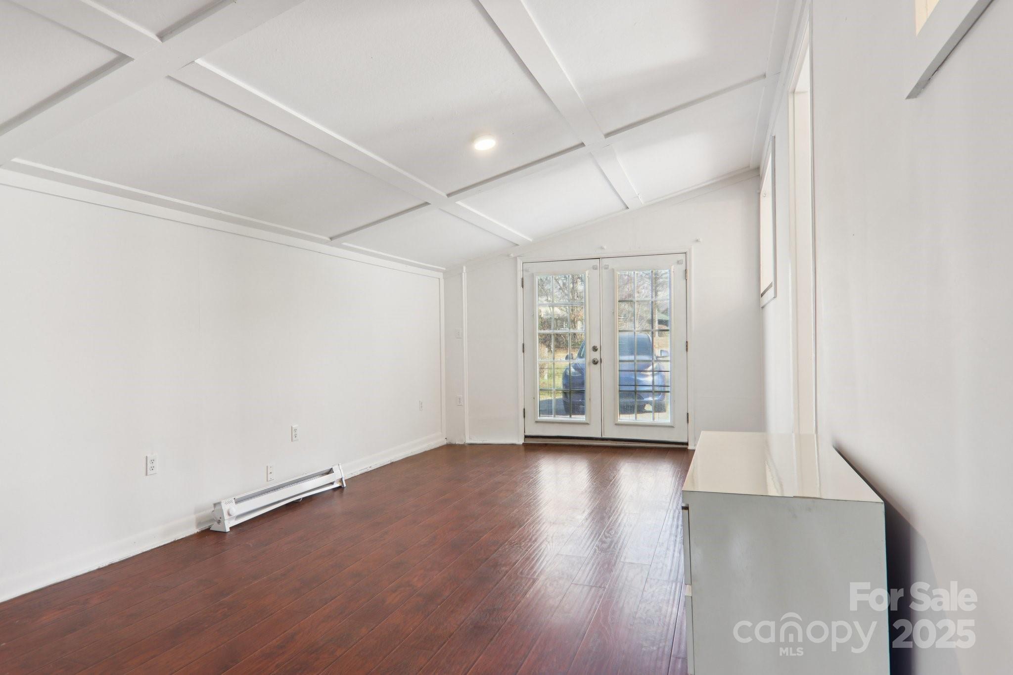 591 Blue Ridge Road Black Mountain, NC 28711 - Photo 23 of 32 an empty room with wooden floor and a floor to ceiling window