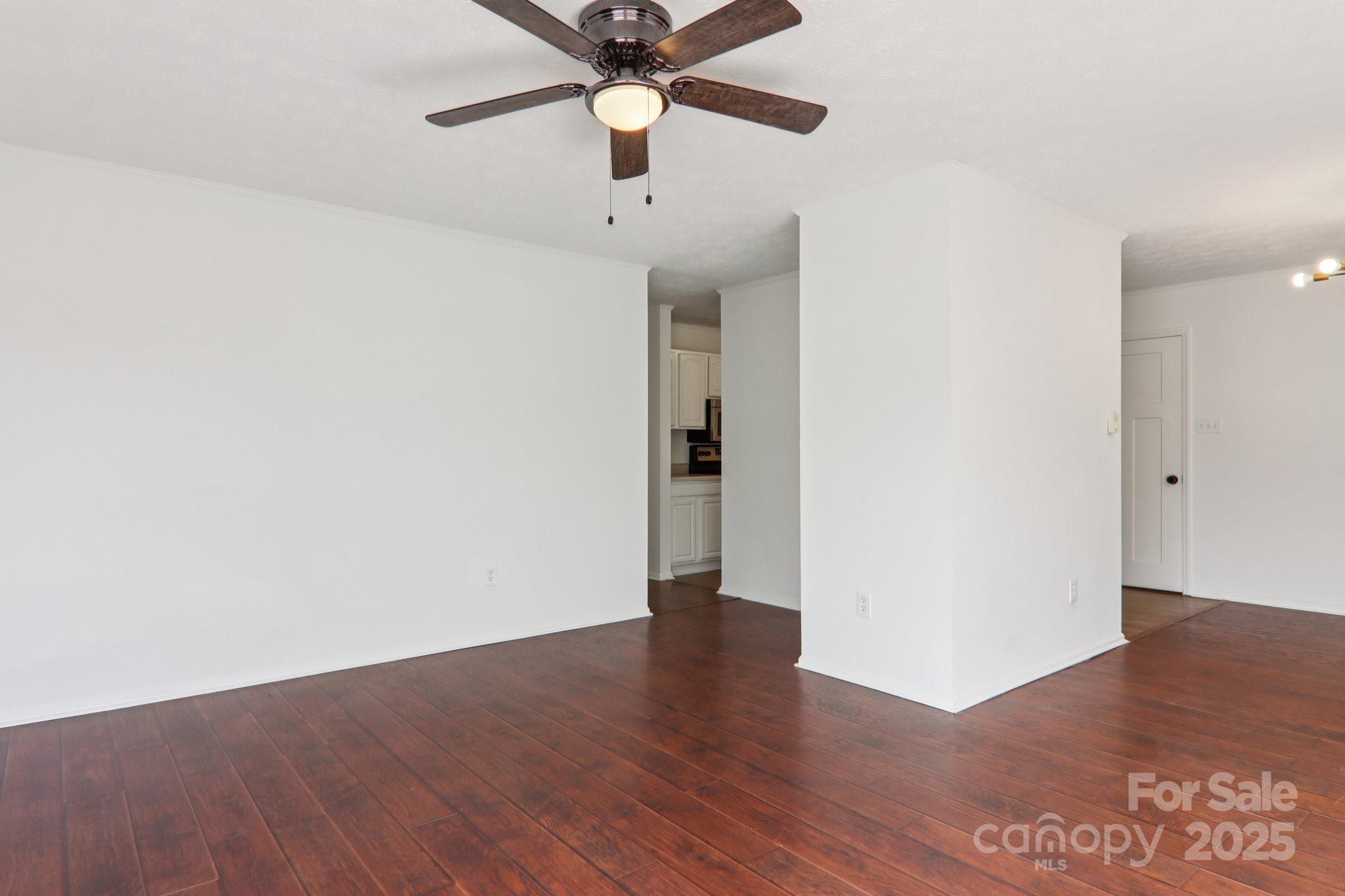 591 Blue Ridge Road Black Mountain, NC 28711 - Photo 5 of 32 an empty room with wooden floor a ceiling fan and closet in a room