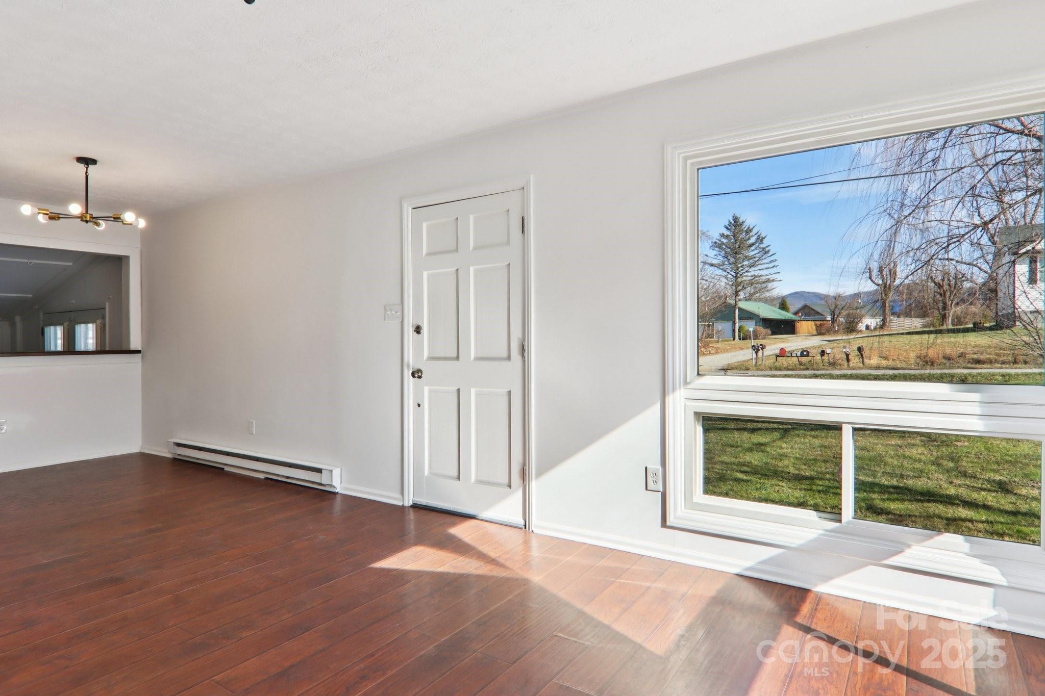 591 Blue Ridge Road Black Mountain, NC 28711 - Photo 8 of 32 a view of an empty room with wooden floor and a window