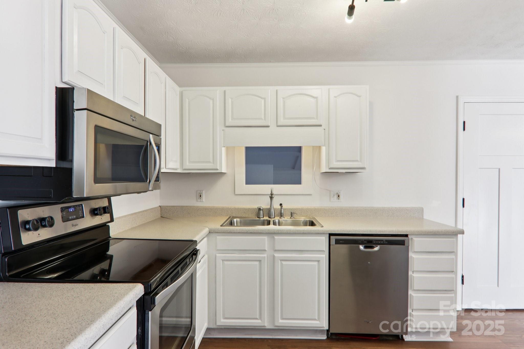 591 Blue Ridge Road Black Mountain, NC 28711 - Photo 10 of 32 a kitchen with white cabinets sink and stainless steel appliances