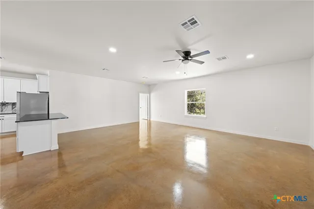 an empty room with a ceiling fan and a window