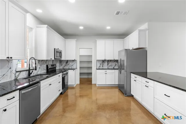 a kitchen with white cabinets and white appliances
