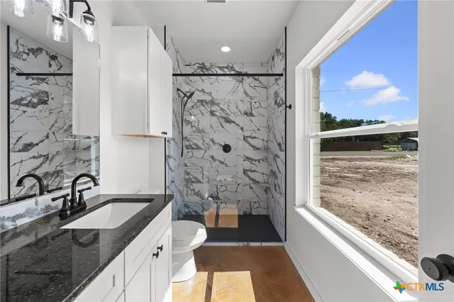a bathroom with a granite countertop sink a bathtub and shower