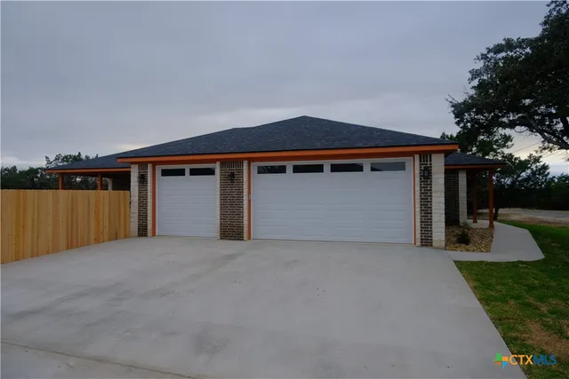 a front view of house with yard and trees in the background