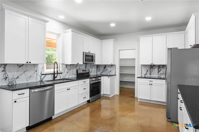a kitchen with white cabinets and white appliances