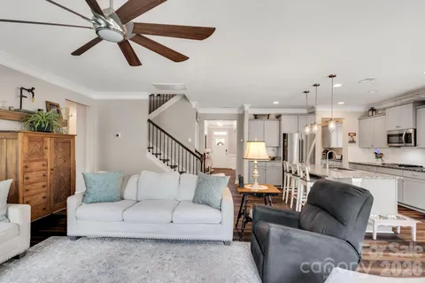a living room with furniture kitchen view and a window