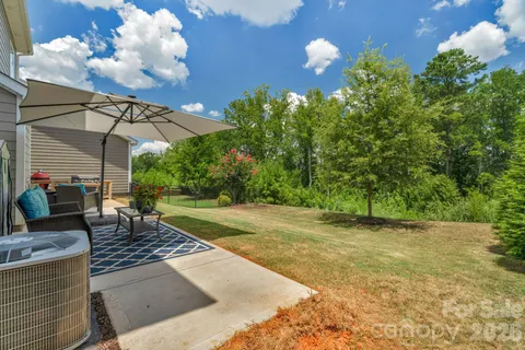 a view of a swimming pool with a patio and a yard