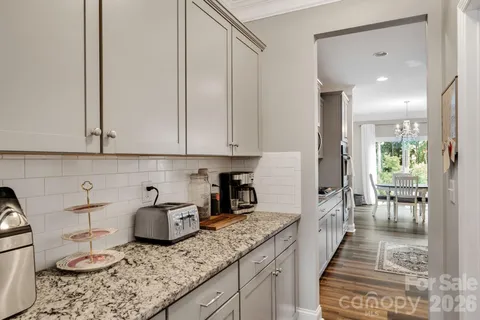 a kitchen with a table chairs and flat screen