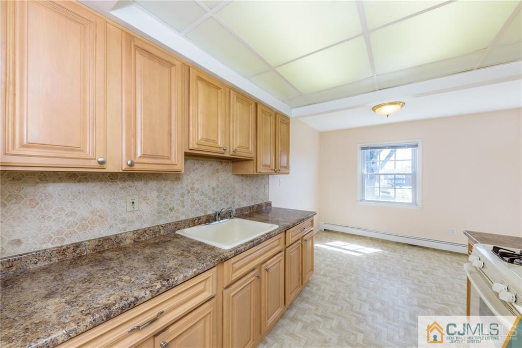 48 Stonehurst Boulevard, Unit E Freehold, NJ 07728 - Photo 11 of 15 a kitchen with a sink and cabinets