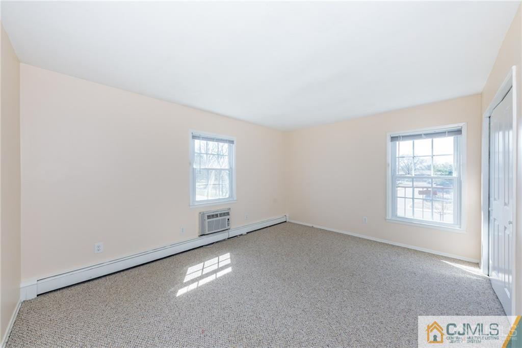 48 Stonehurst Boulevard, Unit E Freehold, NJ 07728 - Photo 12 of 15 an empty room with windows