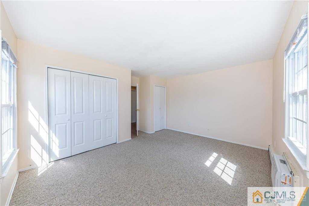 48 Stonehurst Boulevard, Unit E Freehold, NJ 07728 - Photo 13 of 15 a view of an empty room with a window