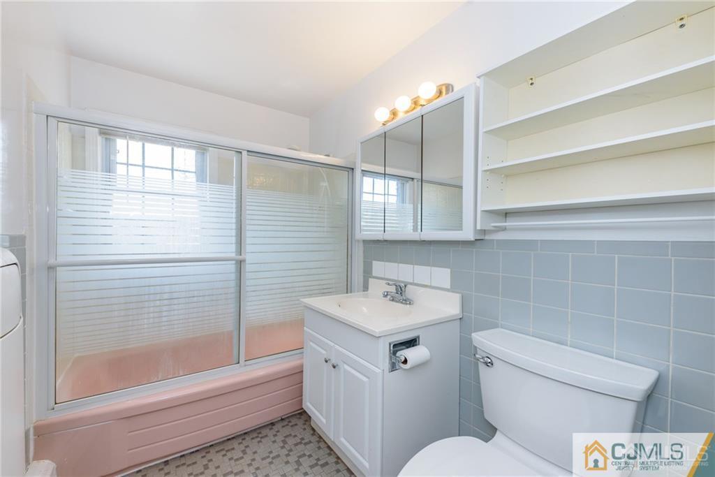48 Stonehurst Boulevard, Unit E Freehold, NJ 07728 - Photo 15 of 15 a bathroom with a sink a toilet and shower