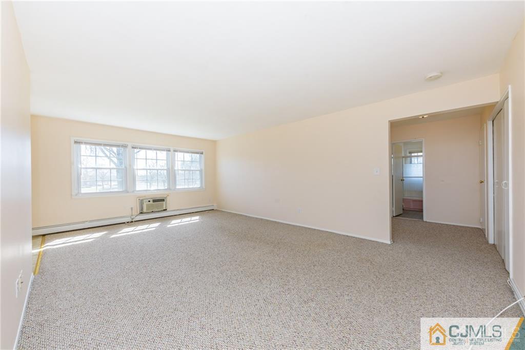 48 Stonehurst Boulevard, Unit E Freehold, NJ 07728 - Photo 5 of 15 an empty room with windows and entrance