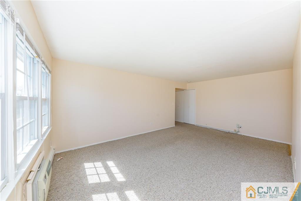48 Stonehurst Boulevard, Unit E Freehold, NJ 07728 - Photo 6 of 15 a view of an empty room and window